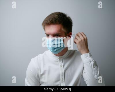 Uomo che indossa una maschera protettiva contro il coronavirus. Personale medico attrezzatura preventiva. Sfondo bianco. Foto Stock