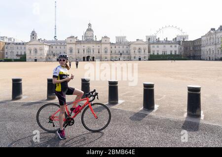 Londra, Regno Unito. Venerdì, 8 maggio, 2020. Un ciclista attende le frecce rosse del cavalcavia nella Parata delle Guardie dei cavalli per commemorare il 75° anniversario della Giornata del Ve. Data foto: Venerdì 8 maggio 2020. Foto: Roger Garfield/Alamy Foto Stock