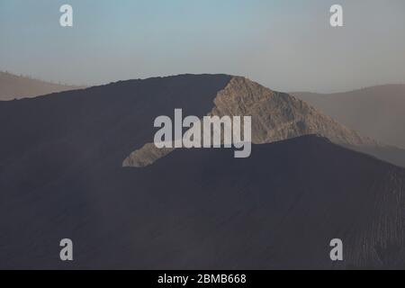 Primo piano della sagoma dell'enorme caldera del vulcano bromo, alla luce della sera, parte del massiccio del Tengger, Giava Orientale, Indonesia. Foto Stock