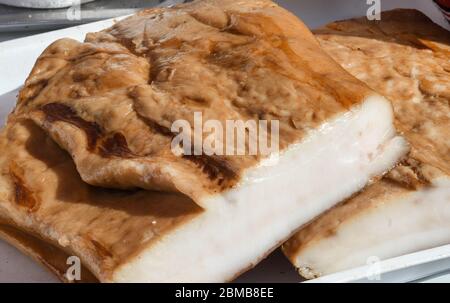 Specialità rumena tradizionale di maiale salato pancia chiamata slanina, sul bancone durante il mercato contadino o fiera di campagna Foto Stock