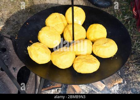 Palle di polenta e formaggio al centro di essa, chiamato bulz, un piatto tradizionale rumeno. Tostatura di polenta e formaggio alla griglia all'esterno, con pecora Foto Stock