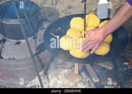 Palle di polenta e formaggio al centro di essa, chiamato bulz, un piatto tradizionale rumeno. Tostatura di polenta e formaggio alla griglia all'esterno, con pecora Foto Stock