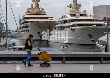 Barcellona, Spagna. 8 maggio 2020. Postino con un carretto che cammina attraverso il porto di Barcellona durante il covid Lockdown Foto Stock