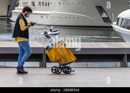 Barcellona, Spagna. 8 maggio 2020. Postino con un carretto che cammina attraverso il porto di Barcellona durante il covid Lockdown Foto Stock