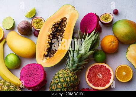 Piatti laici frutti esotici tropicali. Ingredienti salutari per l'estate: Papaya, pitaya, ananas, arancia, lime, uva e mango. Foto Stock