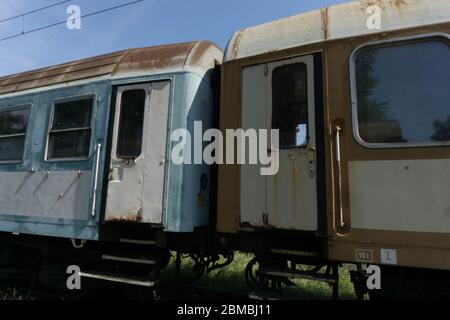 un ultimo parco e treni abbandonati su un paesaggio verde Foto Stock