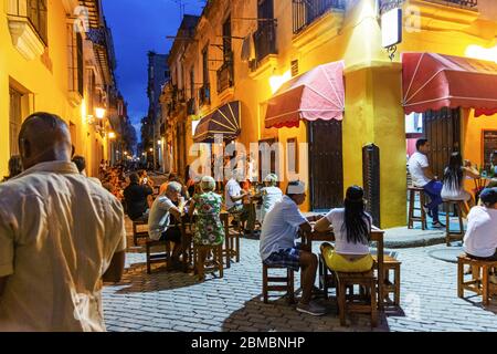 Havana, Cuba - 25 luglio 2018: Turisti e locali mangiano fuori un caffè di notte con musica suonata in un cortile a Cuba Havana. Foto Stock