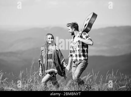 Escursionismo romance. Aria fresca e sentimenti puri. Passeggiata romantica. Canzone romantica. L'amore li ispira. Bella coppia romantica felice volti sorridenti sullo sfondo della natura. Ragazzo e ragazza con la chitarra. Foto Stock