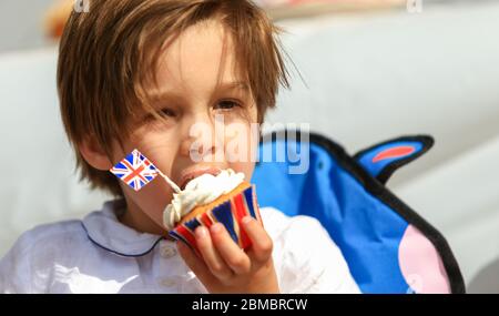 Halesowen, West Midlands, Regno Unito. 8 maggio 2020. Zachary Hickin, 4 anni, gode di una torta a tema del VE Day 75, ognuno dei quali siede nel viaggio di famiglia a Halesowen, West Midlands. Credit: Peter Lopeman/Alamy Live News Foto Stock