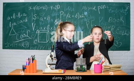 Alla ricerca di una soluzione medica adeguata. Poco scienziato lavoro con microscopio. Bambine in laboratorio. Educazione chimica. Esperimenti scientifici in laboratorio chimico. Ricerca chimica. Lezione di biologia. Foto Stock