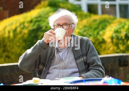 Halesowen, West Midlands, Regno Unito. 8 maggio 2020. Un anziano Signore gode di una tazza di tè molto inglese fuori dalla sua casa il giorno 75 del VE ad Halesowen, Midlands occidentali. Credit: Peter Lopeman/Alamy Live News Foto Stock