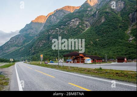 27 luglio 2013, Gudvangen, Norvegia: Un'autostrada con una stazione di servizio sullo sfondo di un bellissimo paesaggio montano. Foto Stock