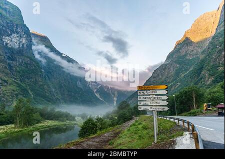 27 luglio 2013, Gudvangen, Norvegia: La fonte del fiordo in montagna vicino alla strada e cartello stradale nella nebbia di prima mattina. Foto Stock