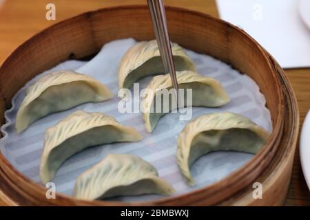 I wontons al vapore serviti in un cesto di bambù nel ristorante DIN Tai Fung del Mall of the Emirates a Dubai Emirati Arabi Uniti, dicembre 2019. Sano, delizioso e fresco Foto Stock