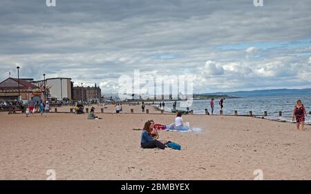 Portobello, Edimburgo, Scozia Regno Unito. 8 maggio 2020. All'osservatore occasionale sembra che alcune persone non stiano prendendo sul serio le distanze sociali come forse lo erano nelle ultime settimane. Anche se la polizia era visibile nel primo pomeriggio, da metà a tardo pomeriggio le persone si trovavano sulla spiaggia e persino una coppia aveva un piccolo barbecue. Credit: Arch White/Alamy Live News. Foto Stock