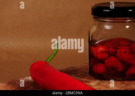 contenitore in vetro con peperoni caldi da vicino Foto Stock