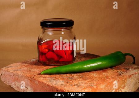 contenitore in vetro con peperoni caldi da vicino Foto Stock