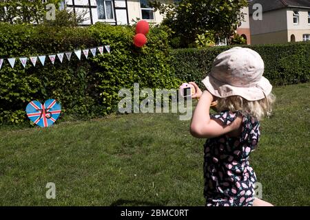 Una giovane ragazza prende una fotografia di un'esposizione del VE Day a Bugbrooke, Northamptonshire Foto Stock