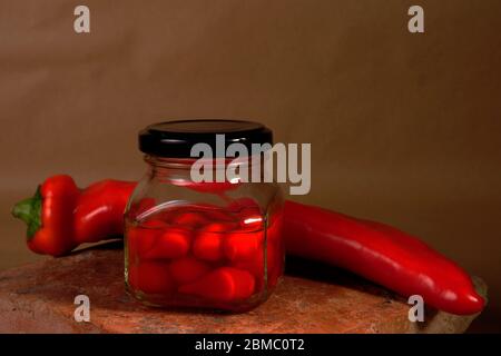 contenitore in vetro con peperoni caldi da vicino Foto Stock