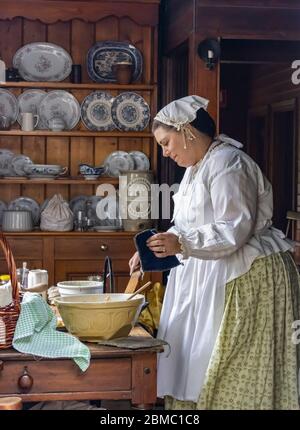 Ballarat, Australia - 7 marzo 2020: Una donna in abiti tradizionali, cucina in una vecchia cucina in una città mineraria dell'oro ricreata. Foto Stock