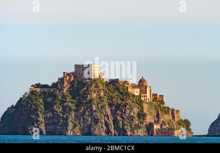 Vista dal mare del romantico castello medievale di Castello Aragonese su un isolotto collegato ad Ischia da un ponte in pietra Golfo di Napoli Foto Stock