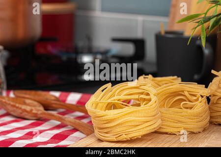 Spaghetti secchi su un bancone da cucina con utensili da cucina Foto Stock