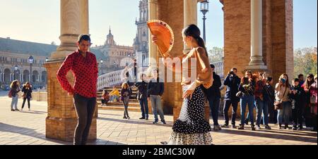 Siviglia, Spagna: 23 dicembre 2019: I turisti godono di uno spettacolo tradizionale di flamenco di strada, spettacolo per i visitatori a Plaza de Espana. Attrazione turistica e divertimento Foto Stock