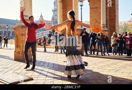 Siviglia, Spagna: 23 dicembre 2019: I turisti godono di uno spettacolo tradizionale di flamenco di strada, spettacolo per i visitatori a Plaza de Espana. Attrazione turistica e divertimento Foto Stock