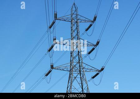 Pilone elettrico con cielo blu sullo sfondo Foto Stock