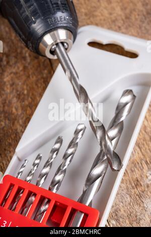 Punte per trapano e cacciavite in metallo. Accessori fai da te in officina. Sfondo scuro. Foto Stock