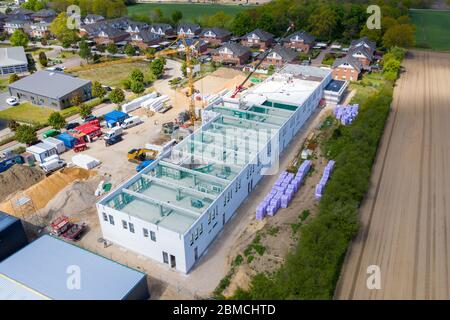 una fotografia a droni di un grande cantiere su cui si sta costruendo un grande locale industriale Foto Stock