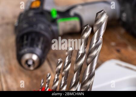 Punte per trapano e cacciavite in metallo. Accessori fai da te in officina. Sfondo scuro. Foto Stock
