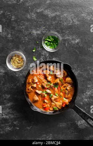 Peri-peri fegatini di pollo in padella su fondo di pietra nera con spazio di testo libero. Vista dall'alto, piatto Foto Stock