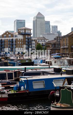 Canary Wharf visto dietro le barche a stretto giro in Limehouse Basin, East London visto durante il blocco dei coronavirus 2020. Foto Stock