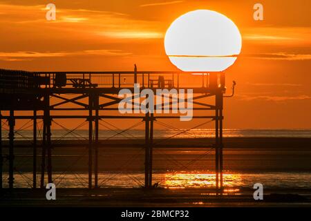 Southport, Merseyside, 8 maggio 2020. Una bella fine della giornata, mentre il sole tramonta sul molo deserte, un punto di riferimento storico lungo la passeggiata a Southport sul Merseyside. Le città di villeggiatura sul mare stanno davvero sentendo il pizzico, come i soliti turisti estivi farebbero riempire i bar e i ristoranti sul lungomare. Credit: Cernan Elias/Alamy Live News Foto Stock