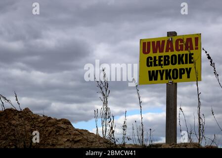 Cartello giallo polacco su una griglia recinto che dice: Attenzione, zona di costruzione, ingresso vietato. Foto Stock