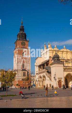 Vista della Sala dei tessuti rinascimentale del XVI secolo (a destra) e della Torre del Municipio Gotica del XIII secolo sulla piazza del mercato (Rynek Glowny) a Cracovia, Pol Foto Stock