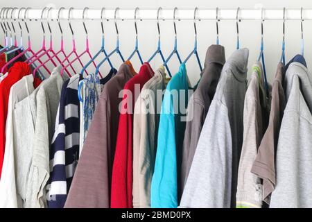 Abbigliamento da uomo e da donna su staffe in silicone nell'armadio. Le stesse spalle. Organizzazione di storage. Ordine e pulizia. Quarantena, se Foto Stock