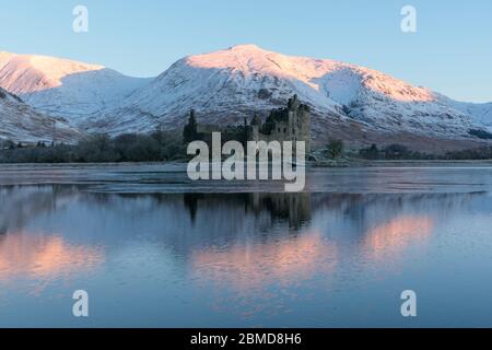 Kilchurn Castle su un lago parzialmente congelato nelle Highlands scozzesi, Scozia Foto Stock