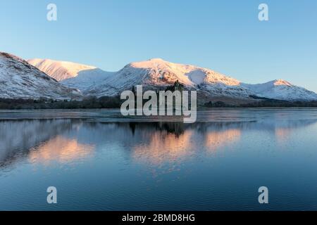 Kilchurn Castle su un lago parzialmente congelato nelle Highlands scozzesi, Scozia Foto Stock