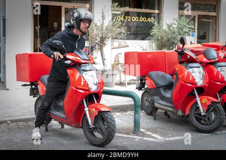 Ragazzo di consegna di decollo su scooter con isotermo cibo scatola di guida veloce. Servizio di consegna di cibo espresso da caffè e ristoranti. Corriere su t Foto Stock