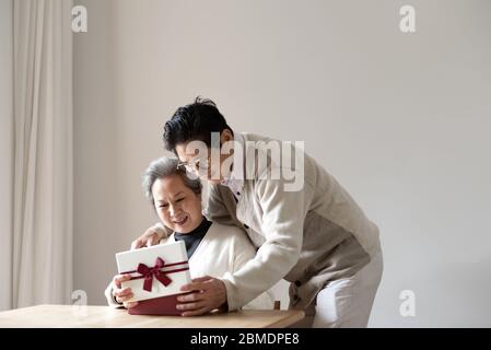 Una coppia asiatica anziana seduta al tavolo Foto Stock