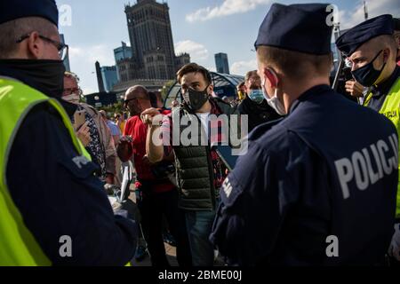 Varsavia, Polonia. 8 maggio 2020. Un protesta di fronte a un poliziotto che sta cercando di identificarlo durante la dimostrazione.il gruppo chiamato 'imprenditori' Strike' guidato dal candidato presidenziale, Pawel Tanajno si è riunito per protestare per il secondo giorno in un crudo contro il 'congelamento dell'economia' a causa della pandemia del virus corona. I manifestanti hanno bloccato il traffico nel centro di Varsavia. Numerosi manifestanti sono stati arrestati durante lo sciopero. Credit: SOPA Images Limited/Alamy Live News Foto Stock