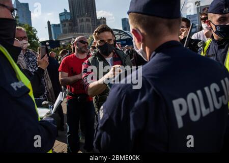 Varsavia, Polonia. 8 maggio 2020. Un protesta di fronte a un poliziotto che sta cercando di identificarlo durante la dimostrazione.il gruppo chiamato 'imprenditori' Strike' guidato dal candidato presidenziale, Pawel Tanajno si è riunito per protestare per il secondo giorno in un crudo contro il 'congelamento dell'economia' a causa della pandemia del virus corona. I manifestanti hanno bloccato il traffico nel centro di Varsavia. Numerosi manifestanti sono stati arrestati durante lo sciopero. Credit: SOPA Images Limited/Alamy Live News Foto Stock