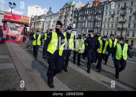 Varsavia, Polonia. 8 maggio 2020. Polizia antisommossa che insegue i manifestanti indossando maschere facciali come precauzione contro la diffusione del virus covid 19, durante la dimostrazione. Il gruppo chiamato 'sciopero imprenditori' guidato dal candidato presidenziale, Pawel Tanajno si è riunito per protestare per il secondo giorno in un crudo contro il 'congelamento dell'economia' a causa della pandemia del virus della corona. I manifestanti hanno bloccato il traffico nel centro di Varsavia. Numerosi manifestanti sono stati arrestati durante lo sciopero. Credit: SOPA Images Limited/Alamy Live News Foto Stock