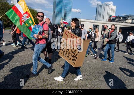 Varsavia, Polonia. 8 maggio 2020. Una donna sta tenendo un cartello che dice 'Stop the fint pandemic' durante la dimostrazione.il gruppo chiamato 'imprenditori' Strike' guidato dal candidato presidenziale, Pawel Tanajno si è riunito per protestare per il secondo giorno in un crudo contro il 'congelamento dell'economia' a causa della pandemia del virus corona. I manifestanti hanno bloccato il traffico nel centro di Varsavia. Numerosi manifestanti sono stati arrestati durante lo sciopero. Credit: SOPA Images Limited/Alamy Live News Foto Stock