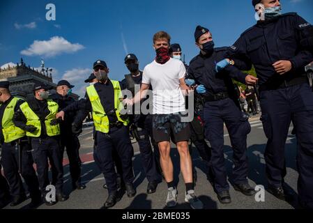 Varsavia, Polonia. 8 maggio 2020. Un protesta arrestato dalla polizia mentre indossa maschere facciali come precauzione contro la diffusione del virus covid 19, durante la dimostrazione. Il gruppo chiamato 'sciopero degli imprenditori' guidato dal candidato presidenziale, Pawel Tanajno si è riunito per protestare per il secondo giorno in un crudo contro il 'congelamento dell'economia' a causa della pandemia del virus della corona. I manifestanti hanno bloccato il traffico nel centro di Varsavia. Numerosi manifestanti sono stati arrestati durante lo sciopero. Credit: SOPA Images Limited/Alamy Live News Foto Stock