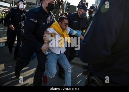 Varsavia, Polonia. 8 maggio 2020. Un protesta arrestato dalla polizia mentre indossa maschere facciali come precauzione contro la diffusione del virus covid 19, durante la dimostrazione. Il gruppo chiamato 'sciopero degli imprenditori' guidato dal candidato presidenziale, Pawel Tanajno si è riunito per protestare per il secondo giorno in un crudo contro il 'congelamento dell'economia' a causa della pandemia del virus della corona. I manifestanti hanno bloccato il traffico nel centro di Varsavia. Numerosi manifestanti sono stati arrestati durante lo sciopero. Credit: SOPA Images Limited/Alamy Live News Foto Stock