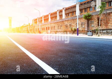 Strada asfaltata dritta all'aperto in vecchia area industriale. Foto Stock