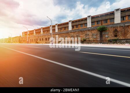 Strada asfaltata dritta all'aperto in vecchia area industriale. Foto Stock